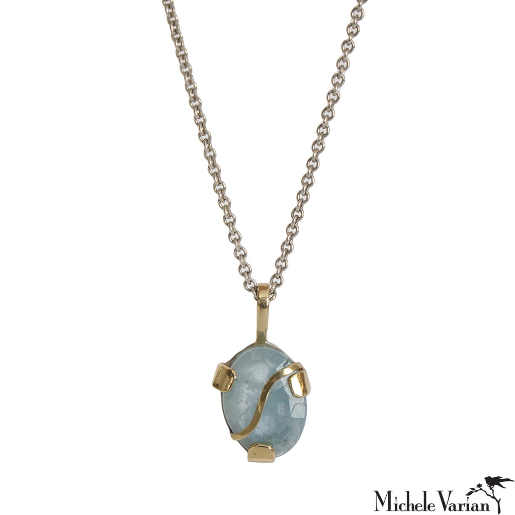 Necklace with a blue pendant and gold accents on a white background.