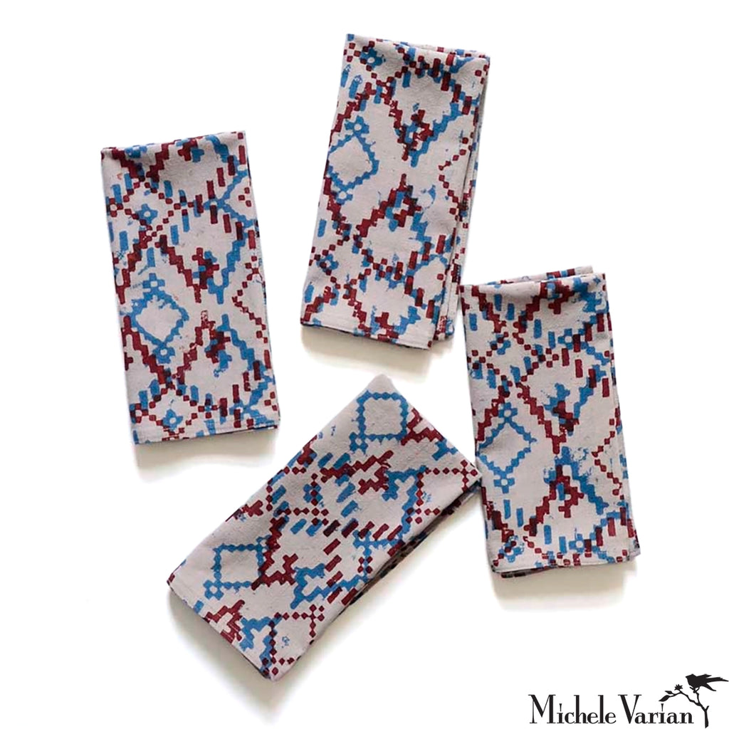 Set of four patterned napkins on a white background.