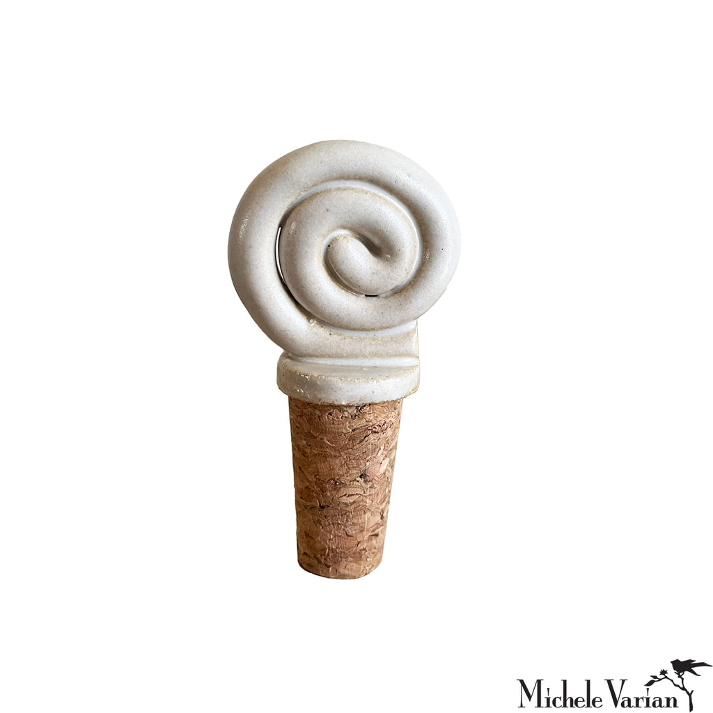 Decorative cork bottle stopper with swirl design on a white background