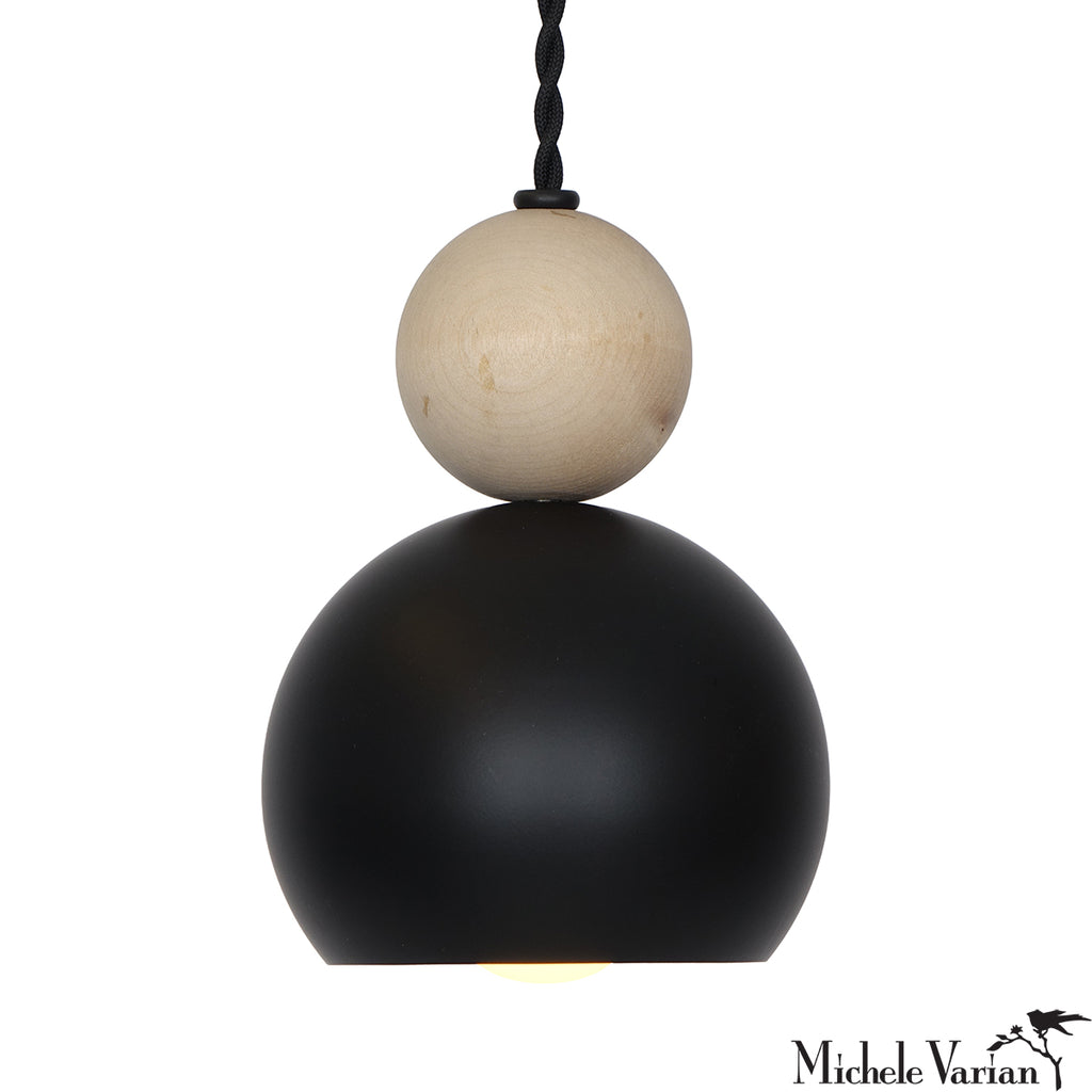 Pendant light with black and beige spherical shades on a white background, designed by Michele Varian.