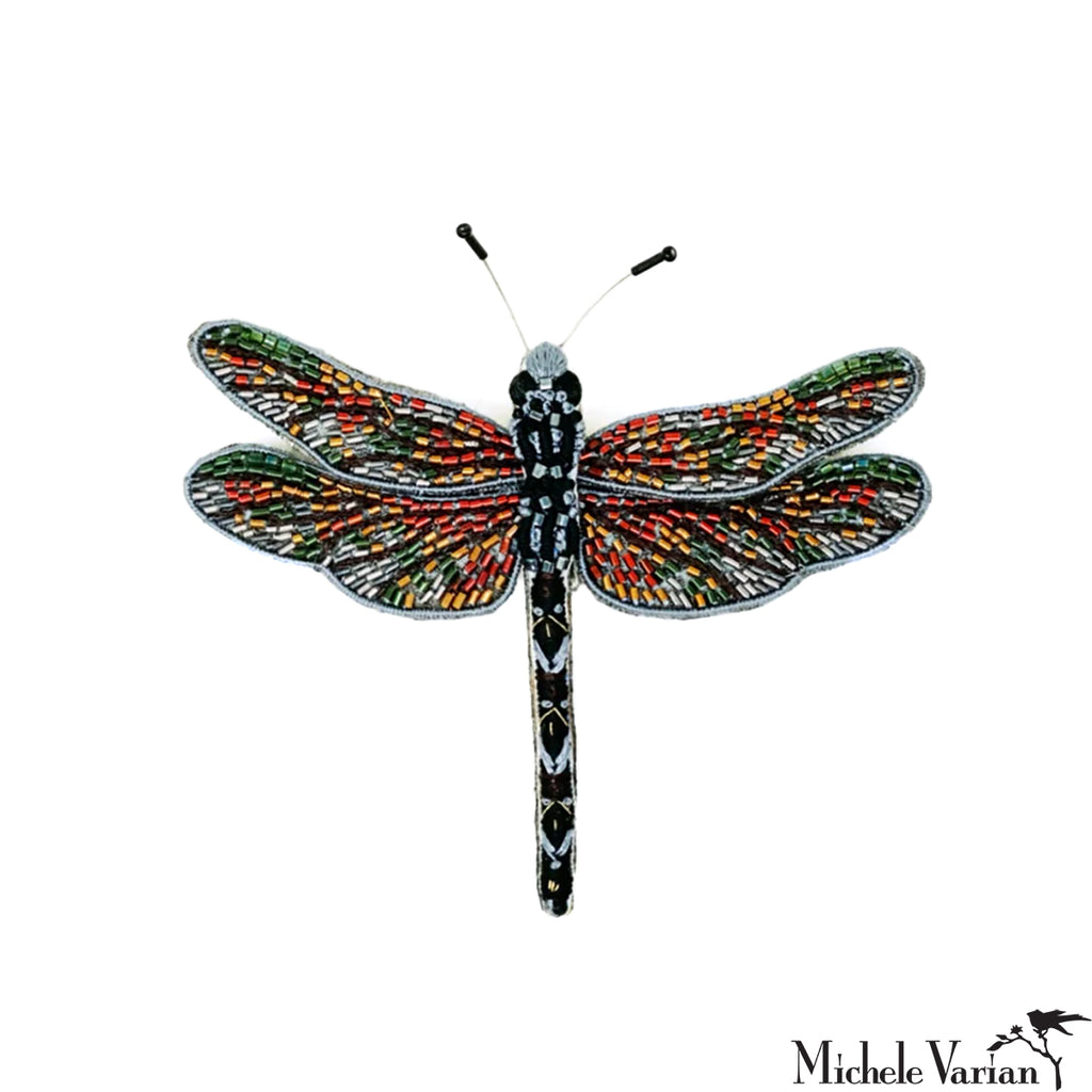 Colorful dragonfly-shaped brooch on a white background