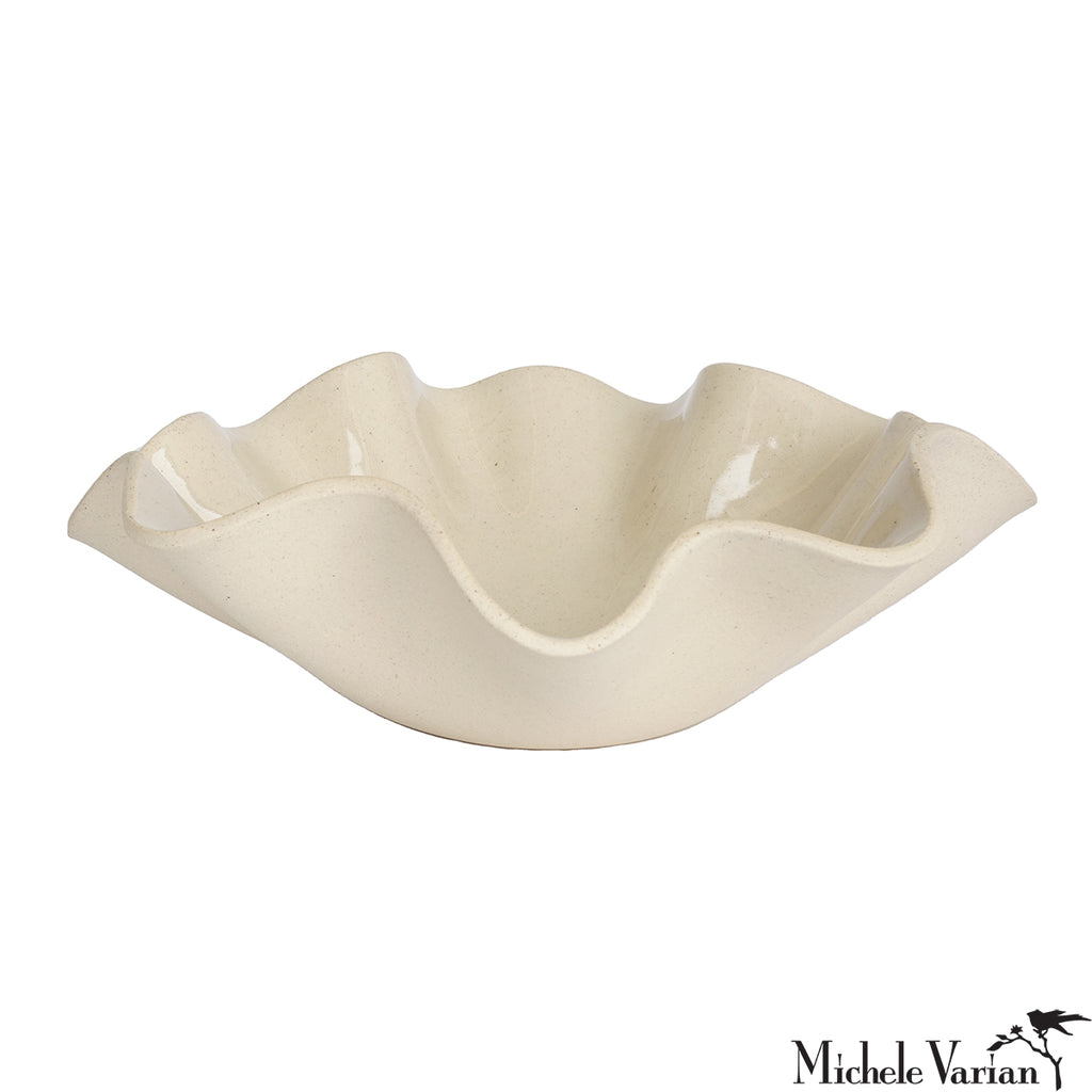 Beige ceramic dish with wavy edge on a white background