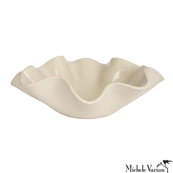 Beige ceramic dish with wavy edge on a white background