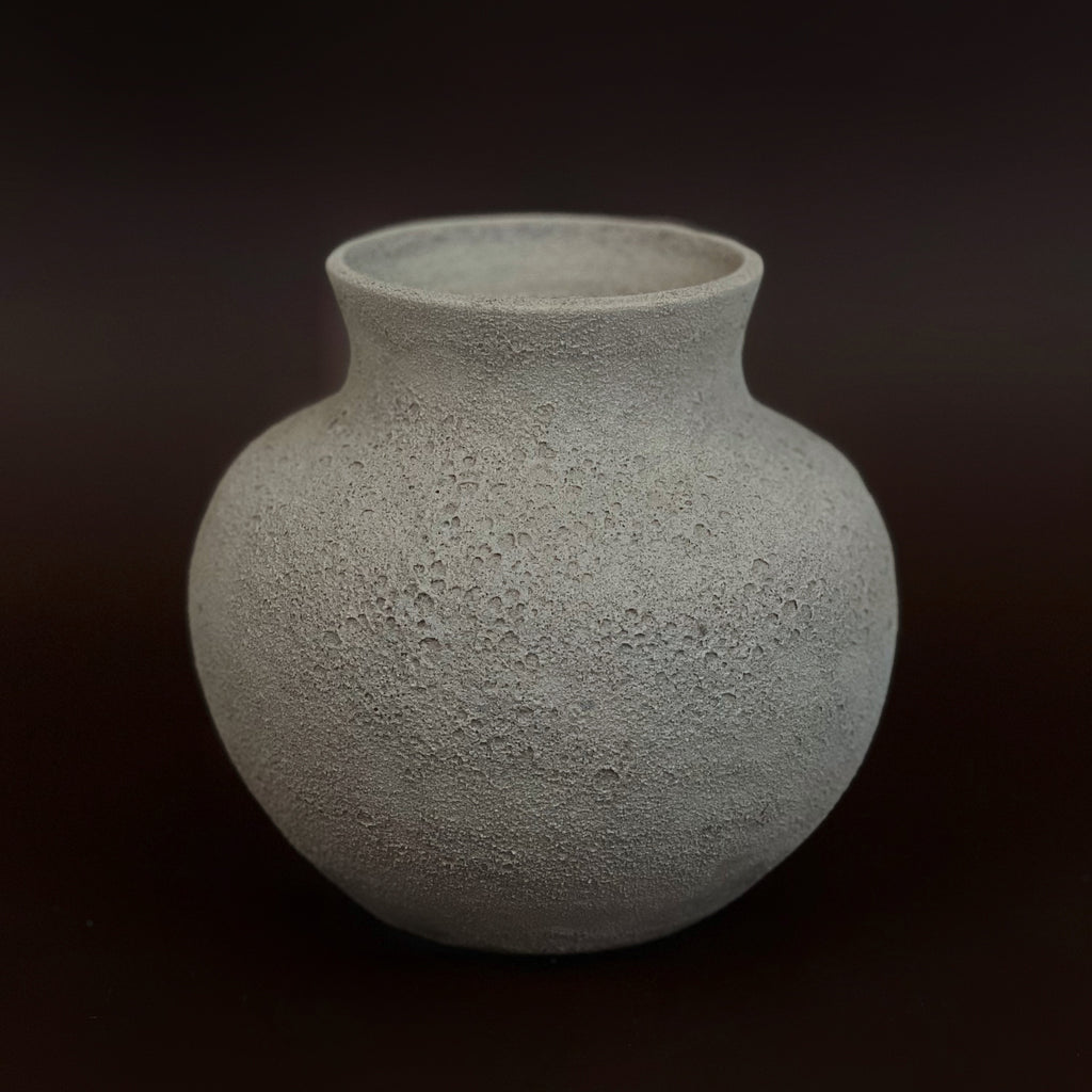 Textured ceramic vase on a dark background