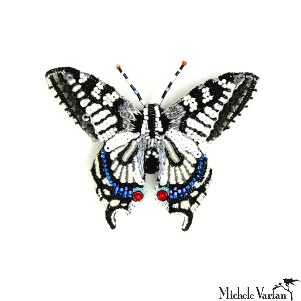 Butterfly-shaped decorative item with beads on a white background