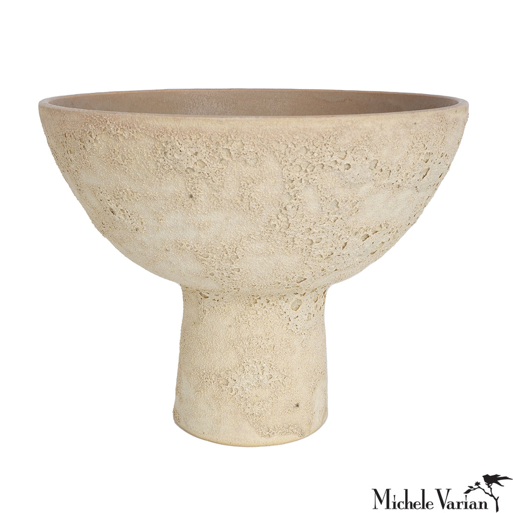 Beige ceramic pedestal bowl on a white background