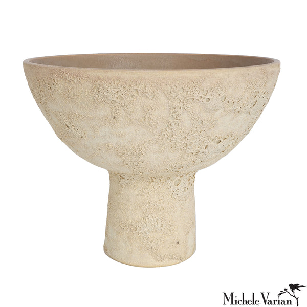 Beige ceramic pedestal bowl on a white background