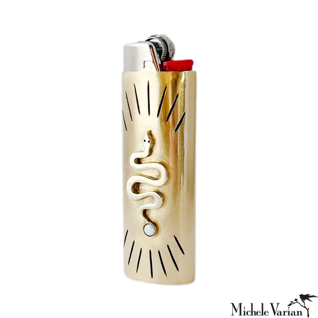 Gold lighter with snake design on a white background