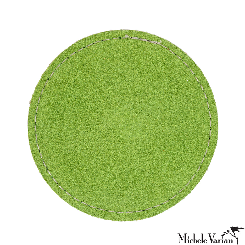 Lime green circular drink coaster with white stitching on a white background.
