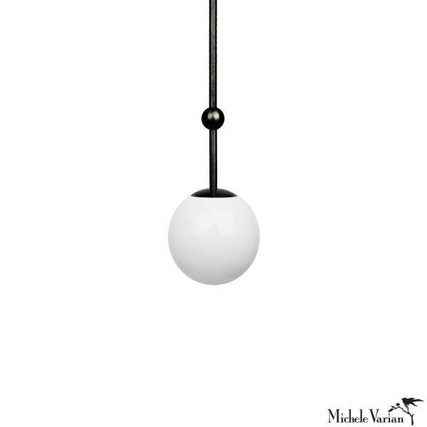 A modern 6 inch black pendant light with a white globe, designed by Michele Varian.